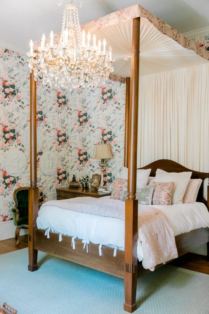 Isom Place bedroom with floral wallpaper and canopy bed
